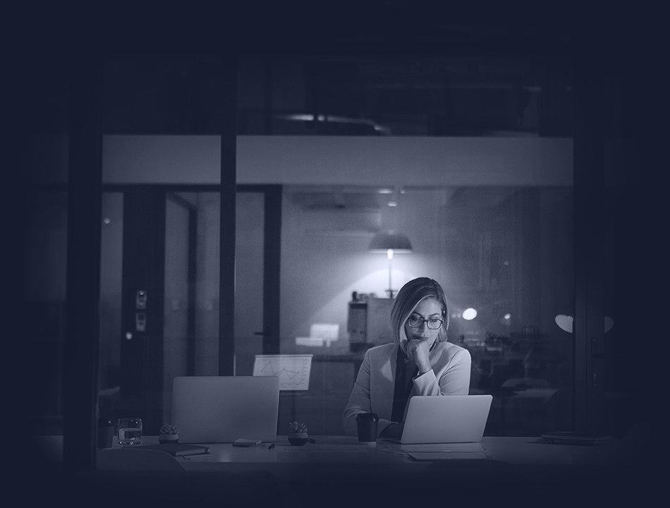 Woman sitting at her desk, looking at laptop